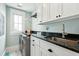 Well-equipped laundry room with modern appliances, granite counters, and ample storage at 511 W Ashley Ave, Folly Beach, SC 29439