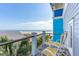 Relaxing oceanview balcony with outdoor seating, complemented by palm trees and coastal charm at 511 W Ashley Ave, Folly Beach, SC 29439