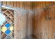 Wood-lined outdoor shower with a shower head and a tiled niche for toiletries to rinse off after a day at the beach at 511 W Ashley Ave, Folly Beach, SC 29439