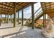 Covered patio features a brick floor, staircase to a deck, and outdoor furniture with a Buddha statue at 511 W Ashley Ave, Folly Beach, SC 29439