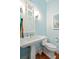 Stylish powder room featuring a pedestal sink, decorative mirror, and elegant lighting at 511 W Ashley Ave, Folly Beach, SC 29439