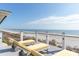 Chairs overlook the sandy beach and blue ocean from the home's spacious rooftop patio at 511 W Ashley Ave, Folly Beach, SC 29439