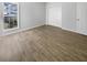 The empty bedroom has light hardwood floors, bright white walls, a large window, and a closet at 5509 Copper Trce, North Charleston, SC 29418