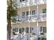 Inviting white home featuring a double porch, accentuated by gray shutters and hanging plants at 610 Daggett St, Daniel Island, SC 29492