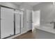 Bathroom features a shower with glass door and white subway tile, white cabinets and grey countertop at 642 Cottage Landing Dr, Summerville, SC 29485
