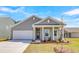 Charming home features a two-car garage, neutral siding, manicured landscaping, and a welcoming front porch at 642 Cottage Landing Dr, Summerville, SC 29485