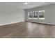Bright open-concept living room with wood floors, large windows, and neutral walls at 642 Cottage Landing Dr, Summerville, SC 29485