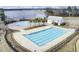 Aerial view of a large outdoor swimming pool with palm trees and a view of the lake in the background at 661 Black Pine Rd, Moncks Corner, SC 29461