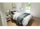 Bedroom with large window, hardwood floors, a queen-size bed, and a nightstand with a lamp at 7614 Indigo Palms Way, Johns Island, SC 29455