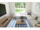 Living room with sectional couch and a window view of the landscaped backyard at 7614 Indigo Palms Way, Johns Island, SC 29455