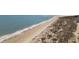 Serene aerial view of a sandy beach meeting the clear blue ocean, perfect for relaxation and recreation at 9002 Palmetto Drive #514 1/13 Share, Isle of Palms, SC 29451