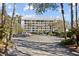 Stunning condo building with multiple floors and lots of parking spaces surrounded by beautiful palm trees at 9002 Palmetto Drive #514 1/13 Share, Isle of Palms, SC 29451