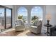 Comfortable living room with two chairs overlooking beach and ocean views from large arched windows at 9002 Palmetto Drive #514 1/13 Share, Isle of Palms, SC 29451