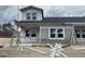 A two-story home is being built and features gray siding and white framed windows with ladders and building materials on the ground at 915 Dusk Dr, Summerville, SC 29486