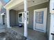 Inviting covered front porch with gray siding, white trim, and a freshly painted front door at 915 Dusk Dr, Summerville, SC 29486