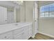 Bright bathroom featuring a white vanity, large mirror, and natural light from the window at 9620 Pebble Creek Blvd, Summerville, SC 29485