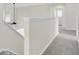 Upstairs hallway with neutral carpet leading to bedrooms, bathed in natural light from a window at 9620 Pebble Creek Blvd, Summerville, SC 29485