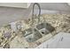 Close-up of kitchen sink with granite countertop and modern faucet at 9620 Pebble Creek Blvd, Summerville, SC 29485