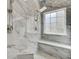 The updated shower features elegant tilework, a built-in bench, and a window for natural light at 9620 Pebble Creek Blvd, Summerville, SC 29485