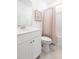 Well-lit bathroom featuring a vanity with white cabinets, a toilet, and a shower with a pink curtain at 103 Pen Shell St, Summerville, SC 29485