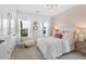 Bright bedroom features natural light, pink accent wall, plush bedding, and a decorative chandelier at 103 Pen Shell St, Summerville, SC 29485