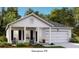 Charming single-story home featuring a covered porch, attached garage, and professionally landscaped yard at 103 Pen Shell St, Summerville, SC 29485