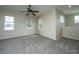 A bright, carpeted room featuring three windows, neutral walls, and a ceiling fan for comfortable living at 1225 Blakeway St # 406, Charleston, SC 29492