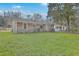 Brick home's backyard with a ladder, lawn, bike, and mature trees, offering space for outdoor living at 1228 Hawthorne Rd, Hanahan, SC 29410