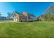 Expansive backyard highlighting a two-story brick home, well-maintained lawn, and a cozy back deck at 1401 Cooper River Blvd, Moncks Corner, SC 29461