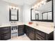 Bathroom featuring vanity with dark wood cabinets, white countertop, and decorative mirrors with modern lighting fixtures at 1401 Cooper River Blvd, Moncks Corner, SC 29461