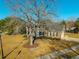 A view of a classic brick home with white columns and dark shutters, surrounded by a spacious yard at 1401 Cooper River Blvd, Moncks Corner, SC 29461