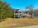 Charming two-story brick home featuring a columned front porch and a well-manicured lawn on a sunny day at 1401 Cooper River Blvd, Moncks Corner, SC 29461