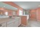 Bathroom featuring double sinks, a soaking tub, a glass shower, and bright peach-painted walls at 146 Stagecoach Ave, Summerville, SC 29486