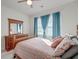 Bright bedroom featuring a wooden dresser with mirror, bed and blue curtains with plenty of natural light at 146 Stagecoach Ave, Summerville, SC 29486