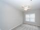 Neutral bedroom with ceiling fan and a window offering natural light, set against soft gray carpeting at 1755 Central Park Rd # 5107, Charleston, SC 29412