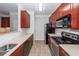 Modern kitchen with cherry cabinets, stainless steel appliances, and neutral backsplash at 1755 Central Park Rd # 5107, Charleston, SC 29412