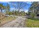 Long gravel driveway leading to a home with a partially visible front porch and mature trees at 1812 Burgess St, Charleston, SC 29412