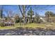 Quaint single-story home with benches, surrounded by mature trees and a grassy lawn at 1812 Burgess St, Charleston, SC 29412