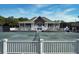 View of tennis court with clubhouse, white railings and staircase, and blue sky in the background at 2017 Long Bend Dr, Seabrook Island, SC 29455