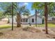 Backyard featuring palms, manicured landscaping, and the home's exterior, partially fenced for privacy at 204 Tram Blvd, Summerville, SC 29486