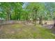 Spacious backyard featuring trees, partial privacy fence and a small patio area for outdoor entertaining at 204 Tram Blvd, Summerville, SC 29486