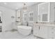 Elegant bathroom featuring double vanity sinks, a free-standing tub, and a stylish chandelier at 213 Amberjack Ln, Charleston, SC 29492