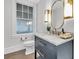 Powder room with marble countertops, custom vanity, gold fixtures, and natural light at 213 Amberjack Ln, Charleston, SC 29492