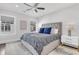 Well-lit bedroom with a large bed with patterned linens, neutral walls, and a ceiling fan at 213 Amberjack Ln, Charleston, SC 29492