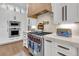 Close up of kitchen with stainless steel appliances, marble countertops, and custom range hood at 213 Amberjack Ln, Charleston, SC 29492