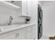 Bright laundry room featuring stacked washer/dryer, white cabinets, a sink and stylish countertops at 213 Amberjack Ln, Charleston, SC 29492