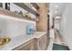 Wet bar with marble countertops, custom shelving, and a blue Smeg coffee maker at 213 Amberjack Ln, Charleston, SC 29492