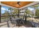 The covered deck provides an inviting outdoor dining area with a ceiling fan and picturesque views of the surrounding landscape at 2156 Cheswick Ln, Mount Pleasant, SC 29466