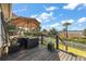 The deck features comfortable outdoor seating with an umbrella, overlooking the scenic waterfront and lush landscaping at 2156 Cheswick Ln, Mount Pleasant, SC 29466