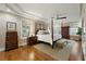 Bright main bedroom boasts a tray ceiling, and a four-poster bed, with hardwood floors and neutral decor at 2156 Cheswick Ln, Mount Pleasant, SC 29466
